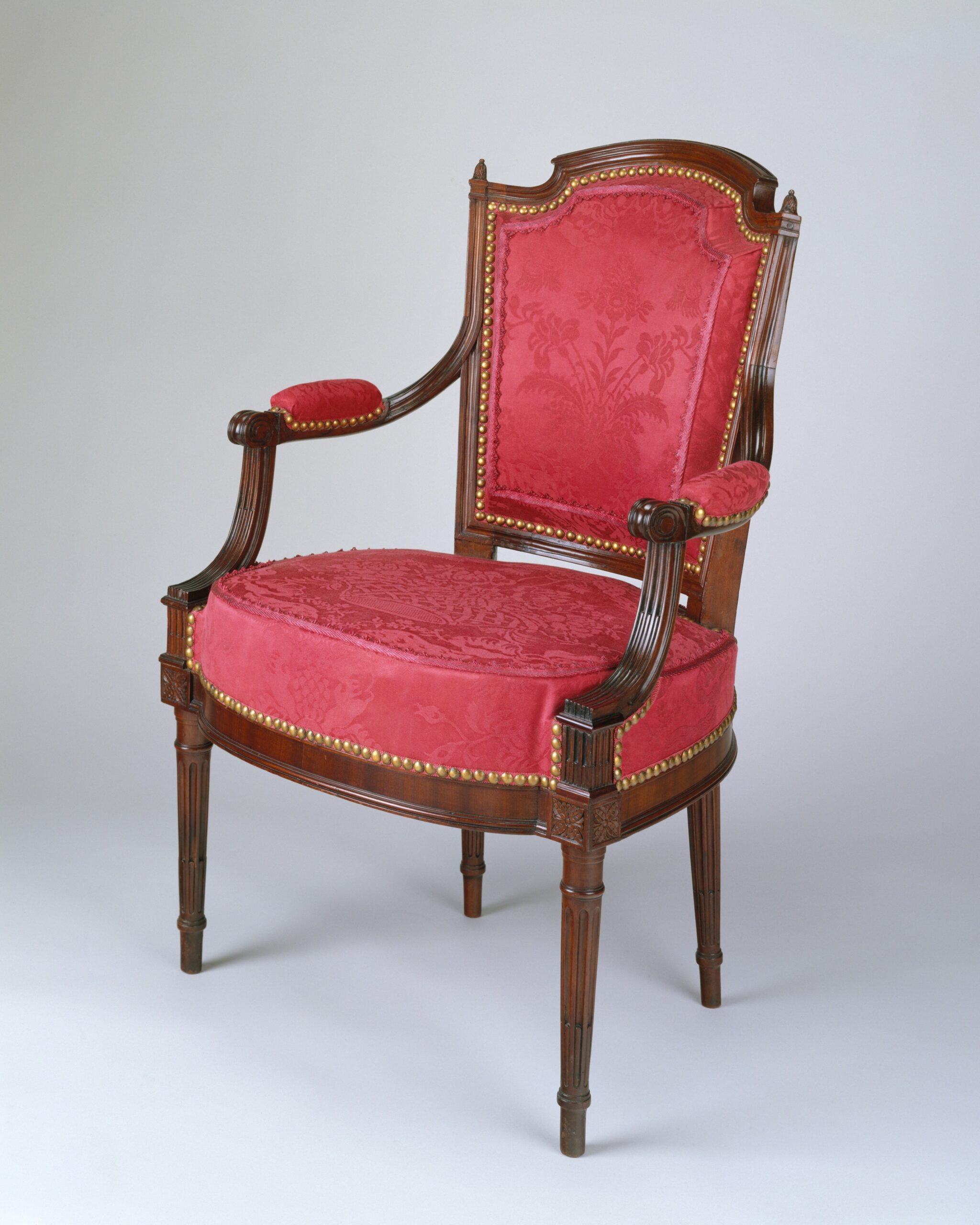 Ce fauteuil, incontestablement de style Louis XVI, a été fabriqué aux États-Unis ; il est attribué à l’ébéniste américain Adam Hains (1768-après1820). Parmi les émigrés français débarquant à Philadelphie ou New York dans les années 1790, fuyant la Révolution, certains étaient artisans. Ils ont repris leur activité professionnelle, introduisant les styles français, notamment le dernier qu’ils ont connu, le style Louis XVI.